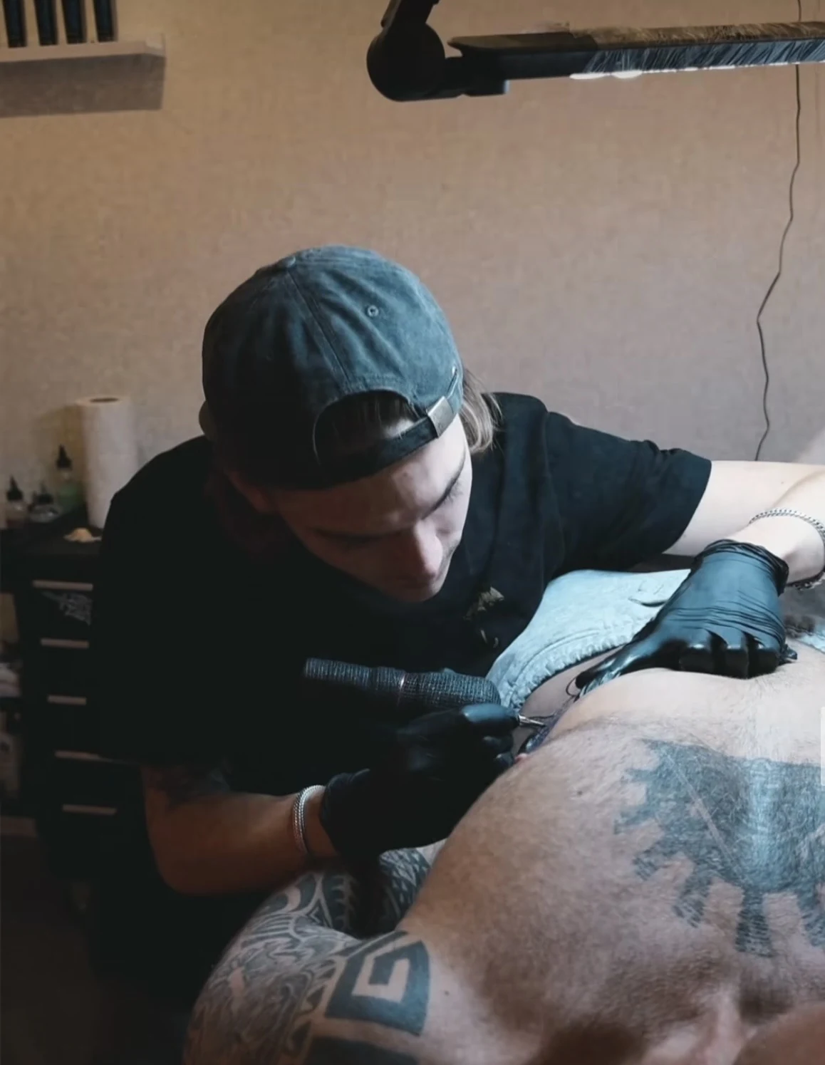 Ravi Brink working on a tattoo during a session.
